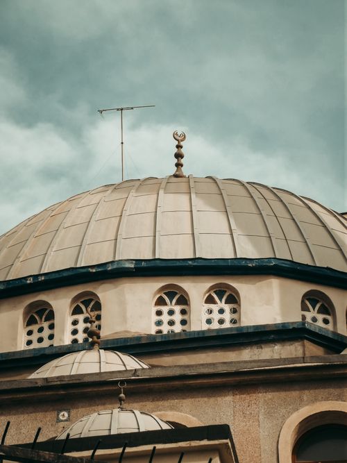 Free Capture of a classic Ottoman mosque dome showcasing intricate architecture under a cloudy sky. Stock Photo