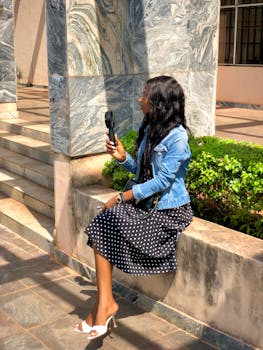 African woman holding a microphone outdoors in Nigeria, exuding urban style.