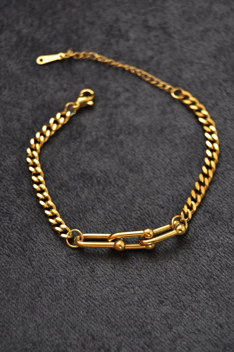 Gold Bracelet On Gray Surface