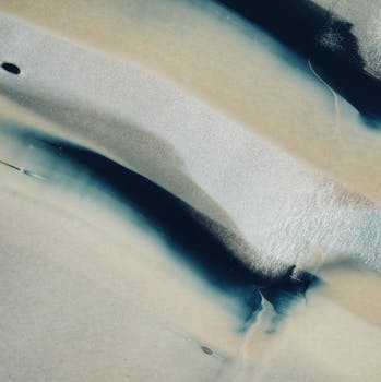 Abstract image featuring fluid blue and white patterns resembling ink on paper.