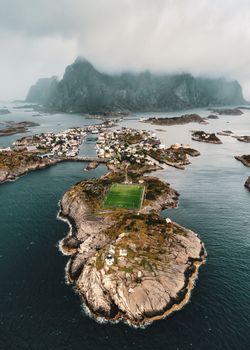 Scenic aerial view of Henningsvær stadium, nestled on a Norwegian island, surrounded by majestic landscapes.