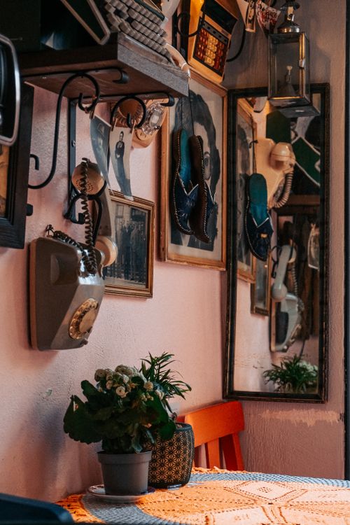Free A nostalgic space featuring vintage items, mirrors, and potted plants on a retro-style shelf. Stock Photo