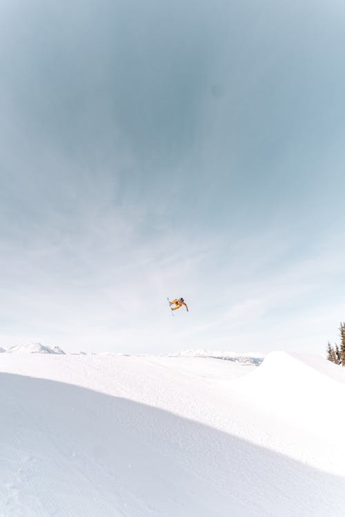 Snowboarder Jumping Over Snowy Hill