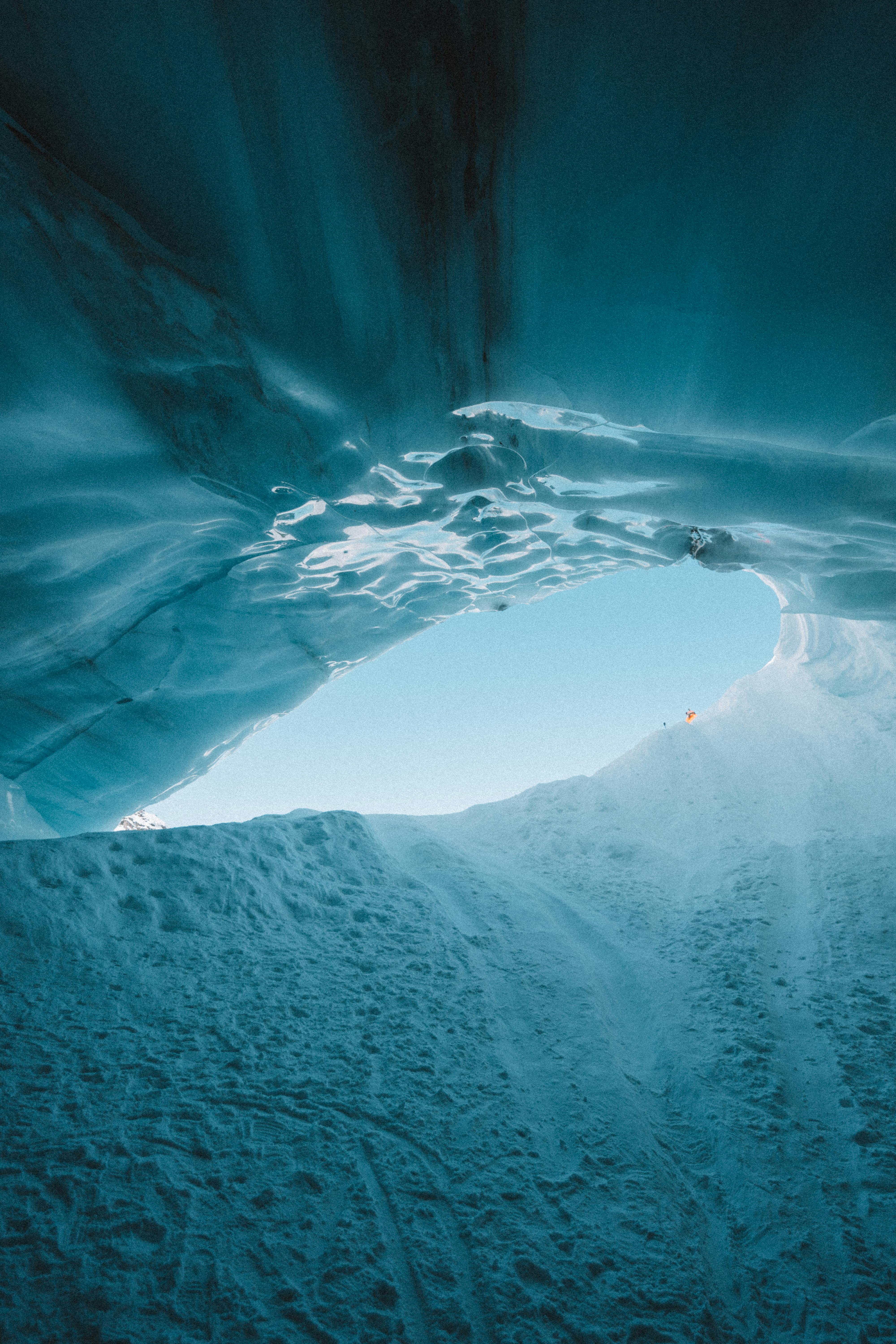 A mesmerizing look from inside an ice cave with a view of the blue sky. Captured in Whistler, Canada.