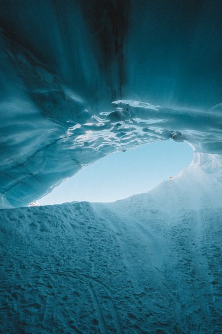 A mesmerizing look from inside an ice cave with a view of the blue sky. Captured in Whistler, Canada.