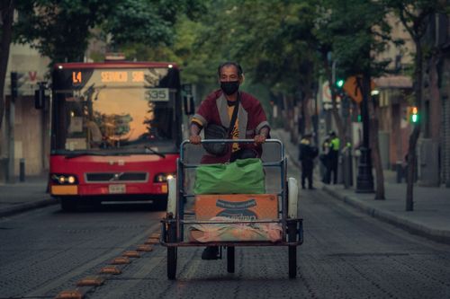 Free A man rides a tricycle loaded with goods on a busy street in Ciudad de México, CDMX. Stock Photo