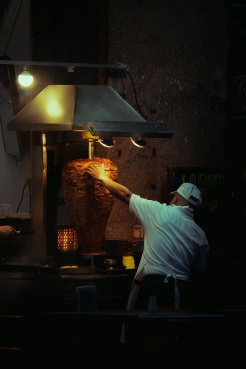 Free Street vendor grilling traditional al pastor tacos at night in Mexico City. Stock Photo