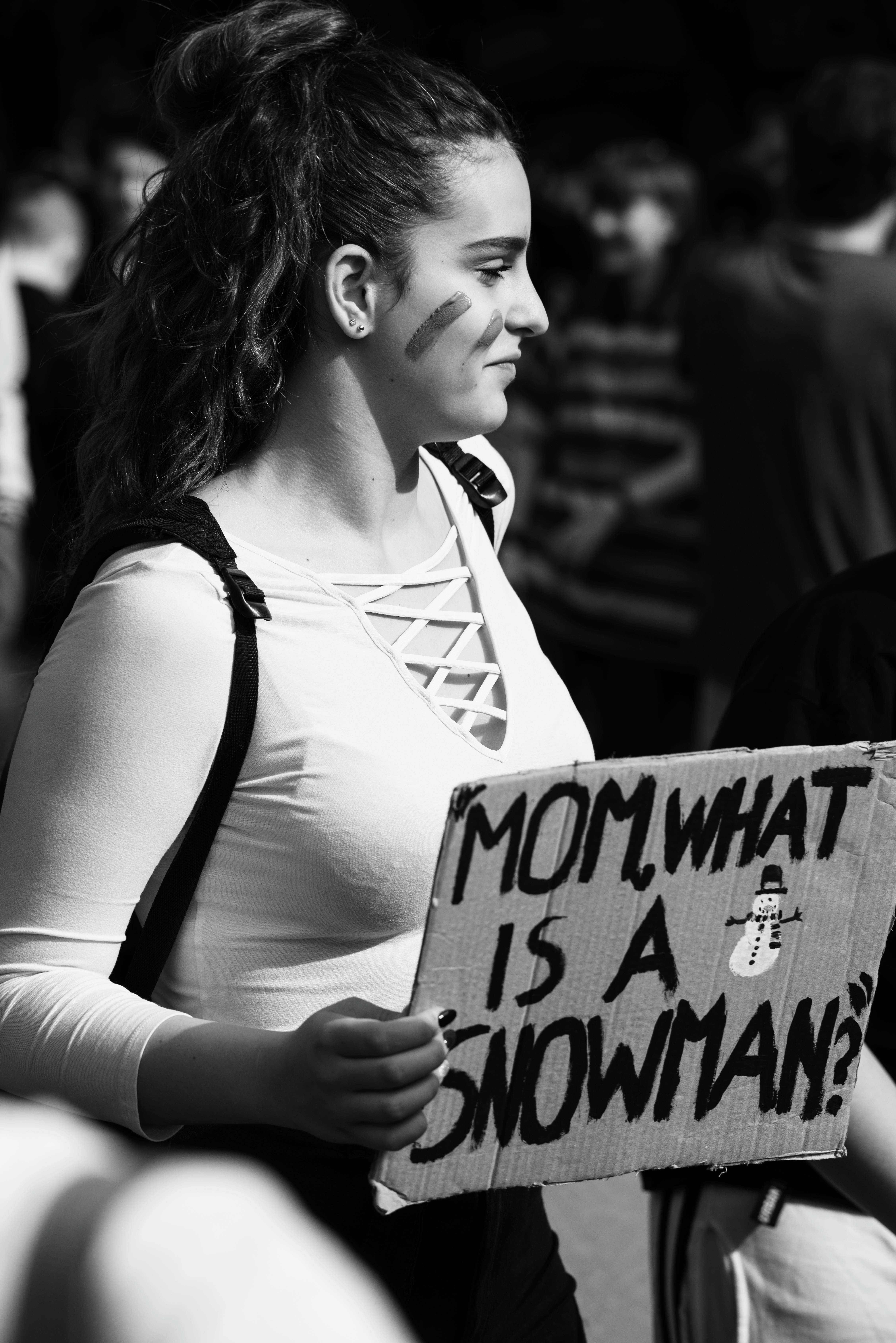 grayscale photo of woman carrying sign