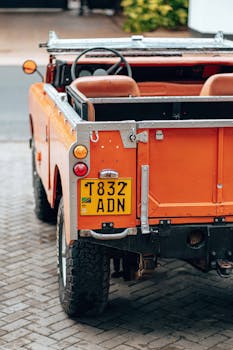 Rear view of a classic orange Land Rover parked in Dar es Salaam, Tanzania.