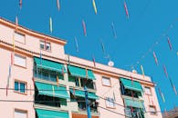 现代建筑的立面，在清澈蓝天的映衬下，点缀着充满活力的遮阳篷和旗帜