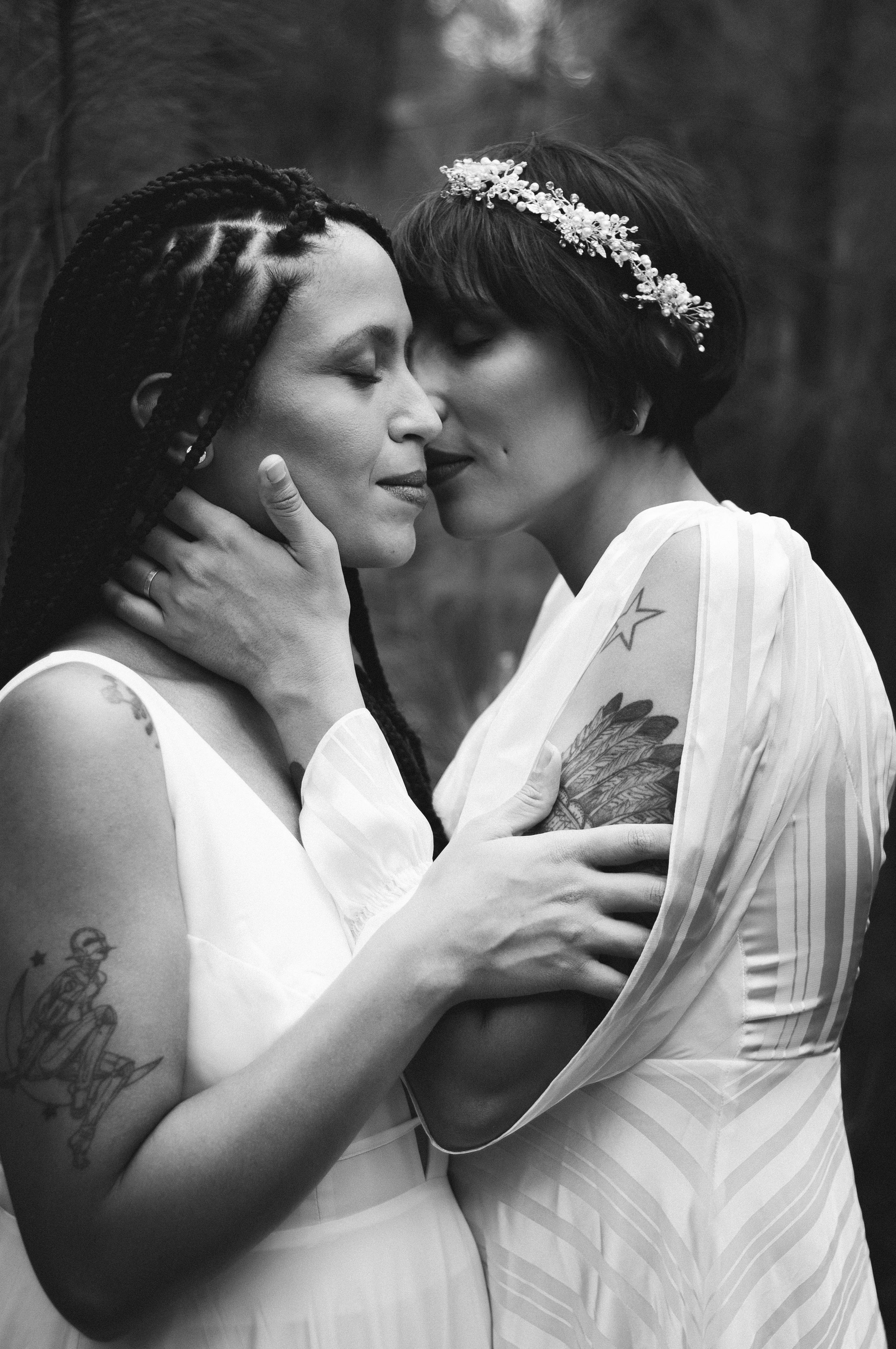 two embracing women in wedding dresses in black and white