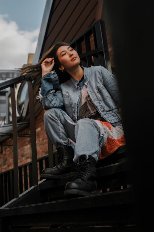 Woman in Denim Jacket Sitting on Stairs