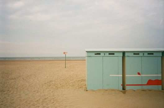 Tranquil beach view in Dunkirk, France featuring beach cabins and the sea horizon.