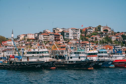 Docked Boats on Sea Port Near City Buildings