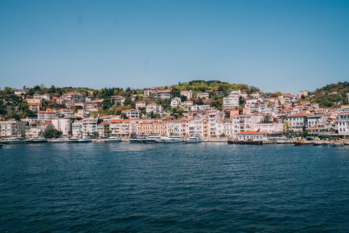 Free Charming coastal town with vibrant houses along the serene blue sea. Stock Photo