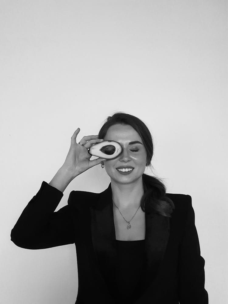 Woman In Black Blazer Holding Sliced Avocado