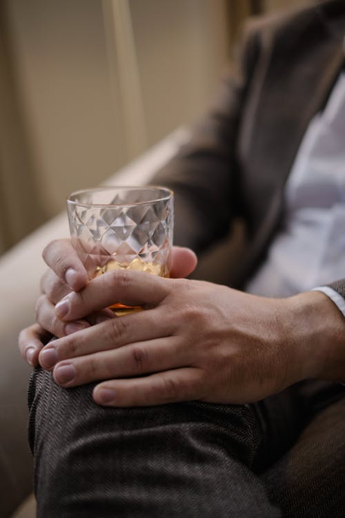 Person Holding Clear Drinking Glass With Liquor