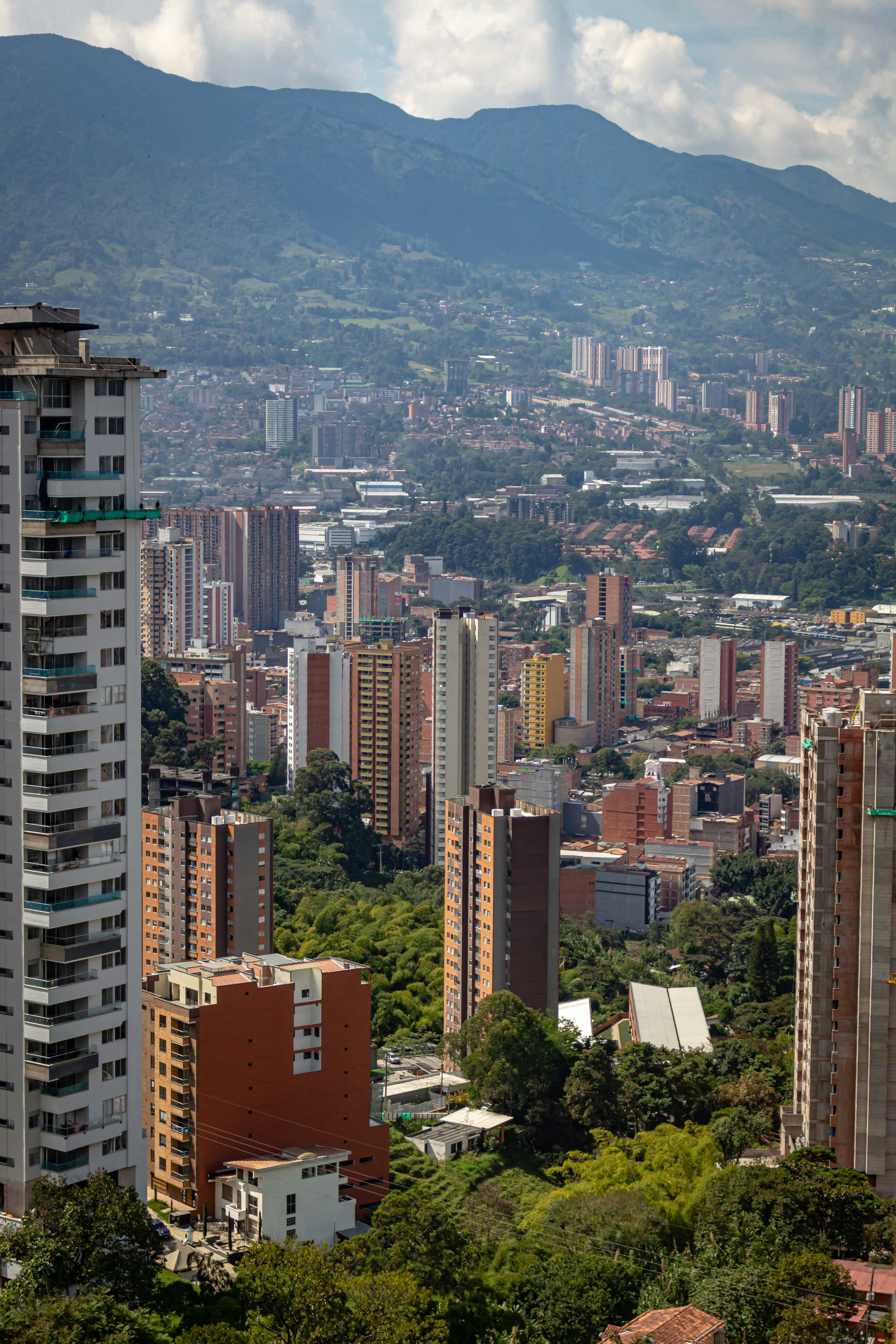 A stunning aerial cityscape of Medellín, Colombia framed by mountain ranges.