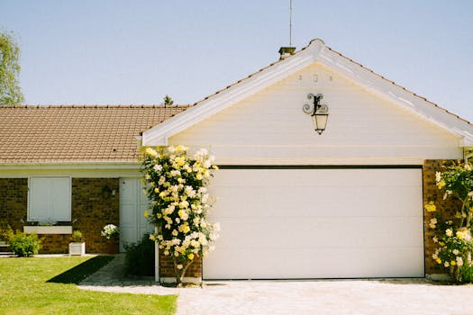 A lovely suburban home with a prominent garage and flowering plants, epitomizing suburban charm and tranquility.