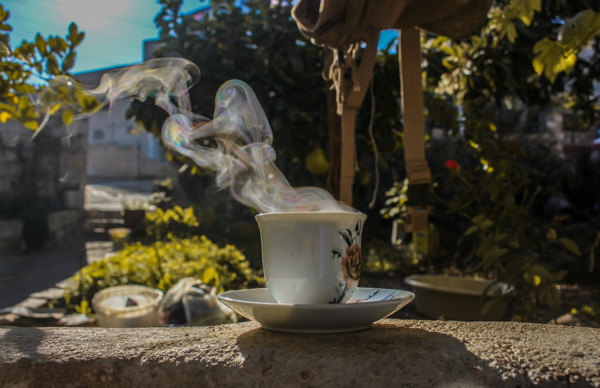 A steaming cup of coffee in a sunny outdoor setting in Aaqrabâte, Syria.