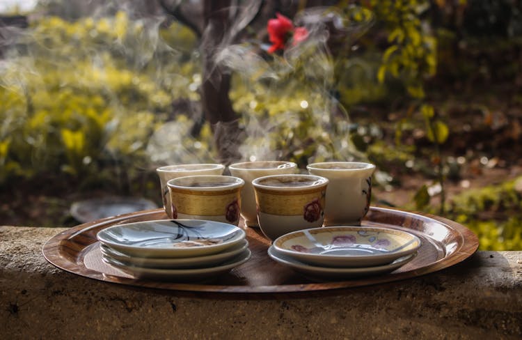 White Floral Tea Cups And Saucers On Brown Wooden Tray