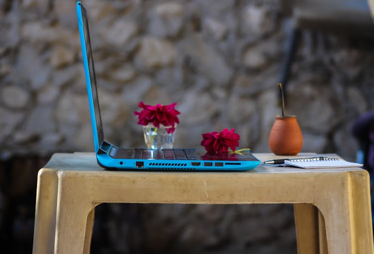 Red Dahlia Flowers On Top Of Blue Laptop Computer