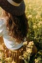 Woman with Long Hair Sitting in Canola Field