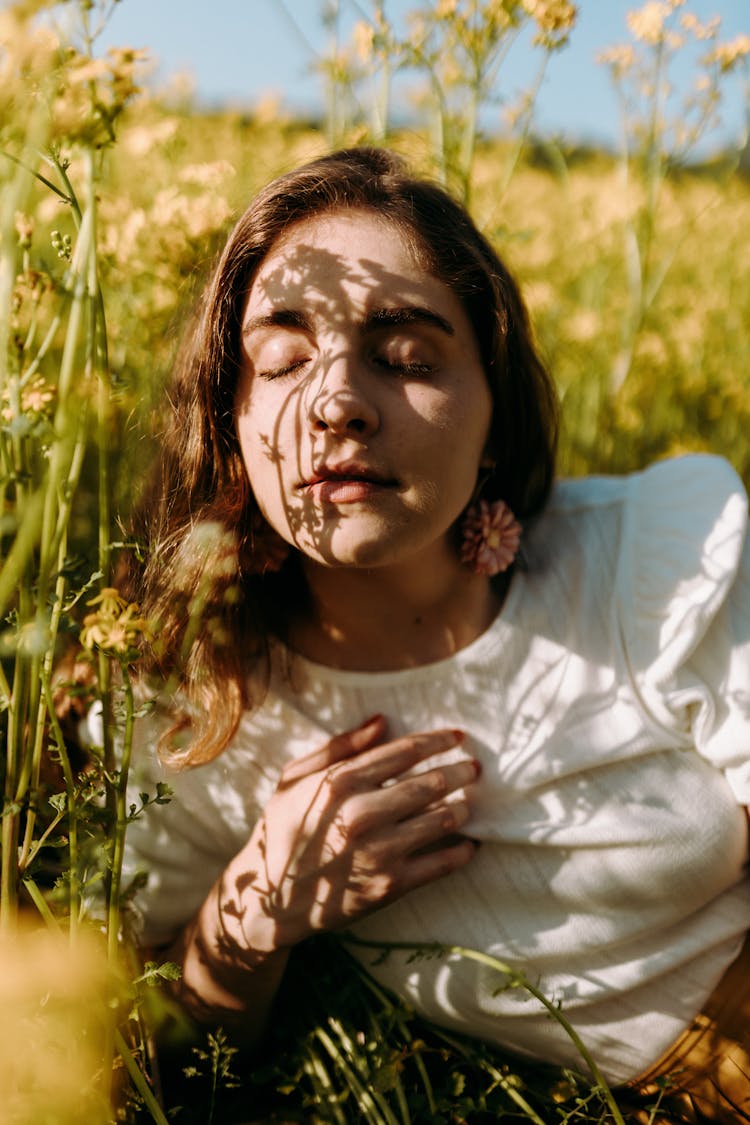 Woman Lying In A Meadow Amidst Flowers