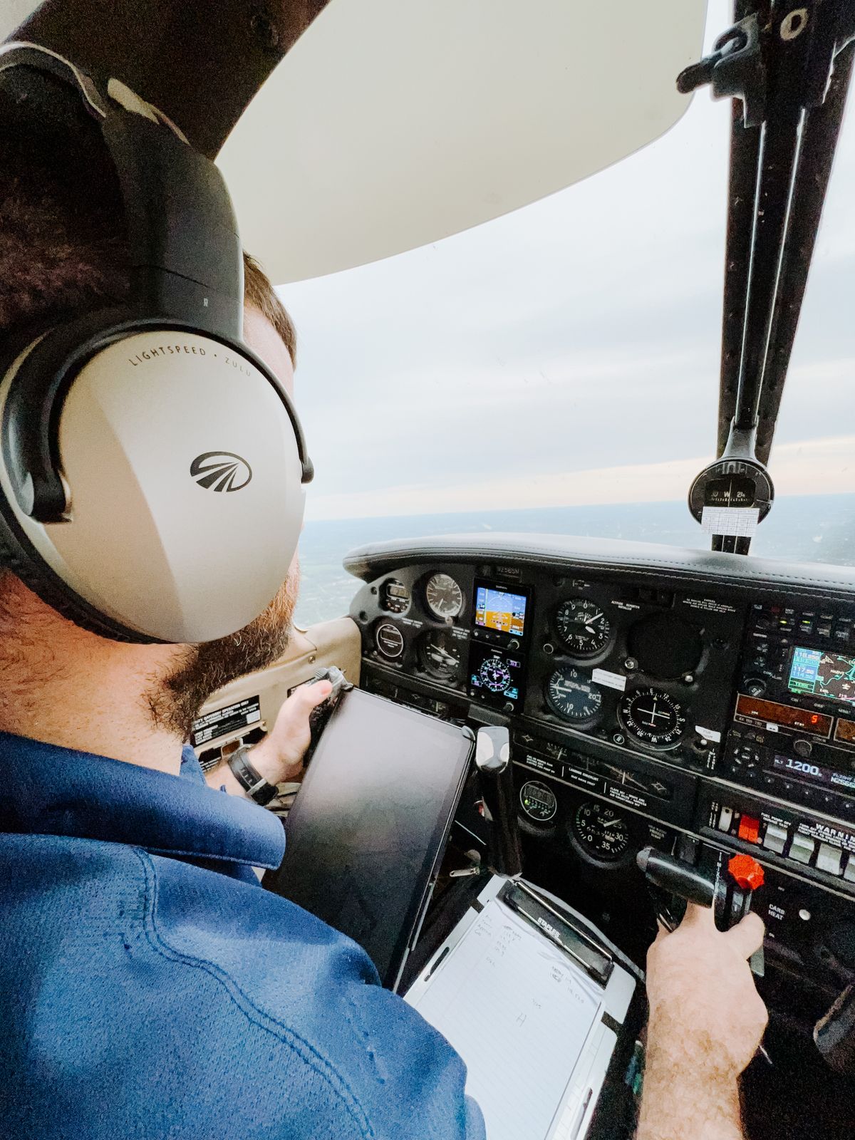 GA pilot in cockpit wearing headset during a backcountry flying adventure