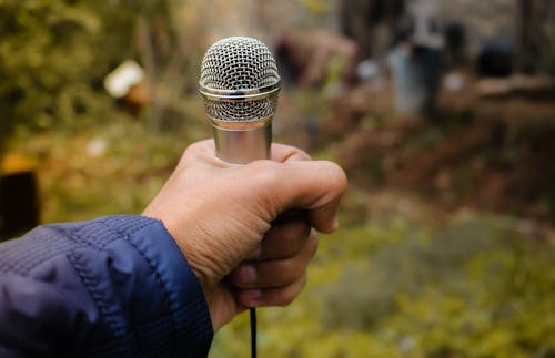 Gratis Fotografi Close Up Orang Yang Memegang Mikrofon Foto Stok