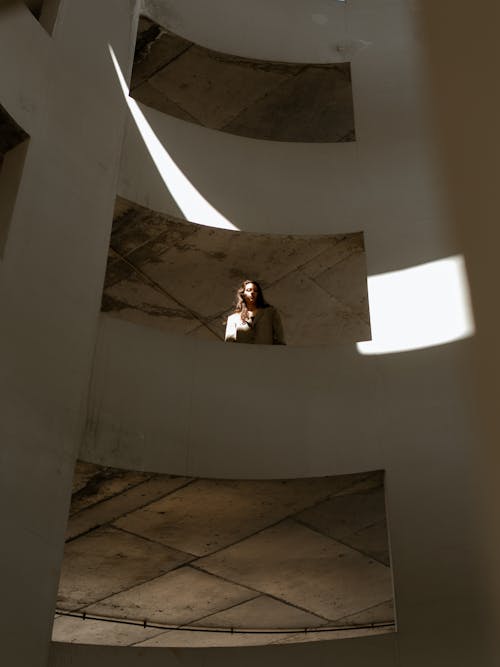Free Woman Visible Through an Open Space of a Tower Stock Photo