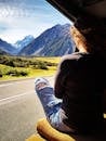 在新西兰坎特伯雷，一名妇女坐在货车里，欣赏着壮丽的山脉景色
