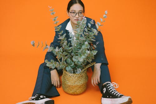 Woman Sitting with a Potted Plant between her Legs