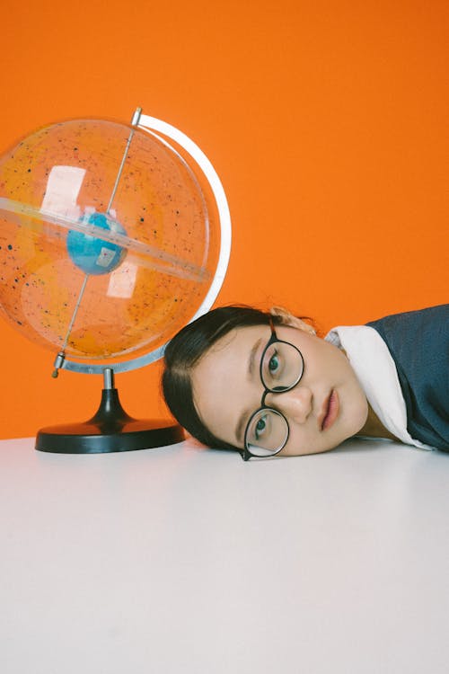 Woman Laying her Head next to a Globe