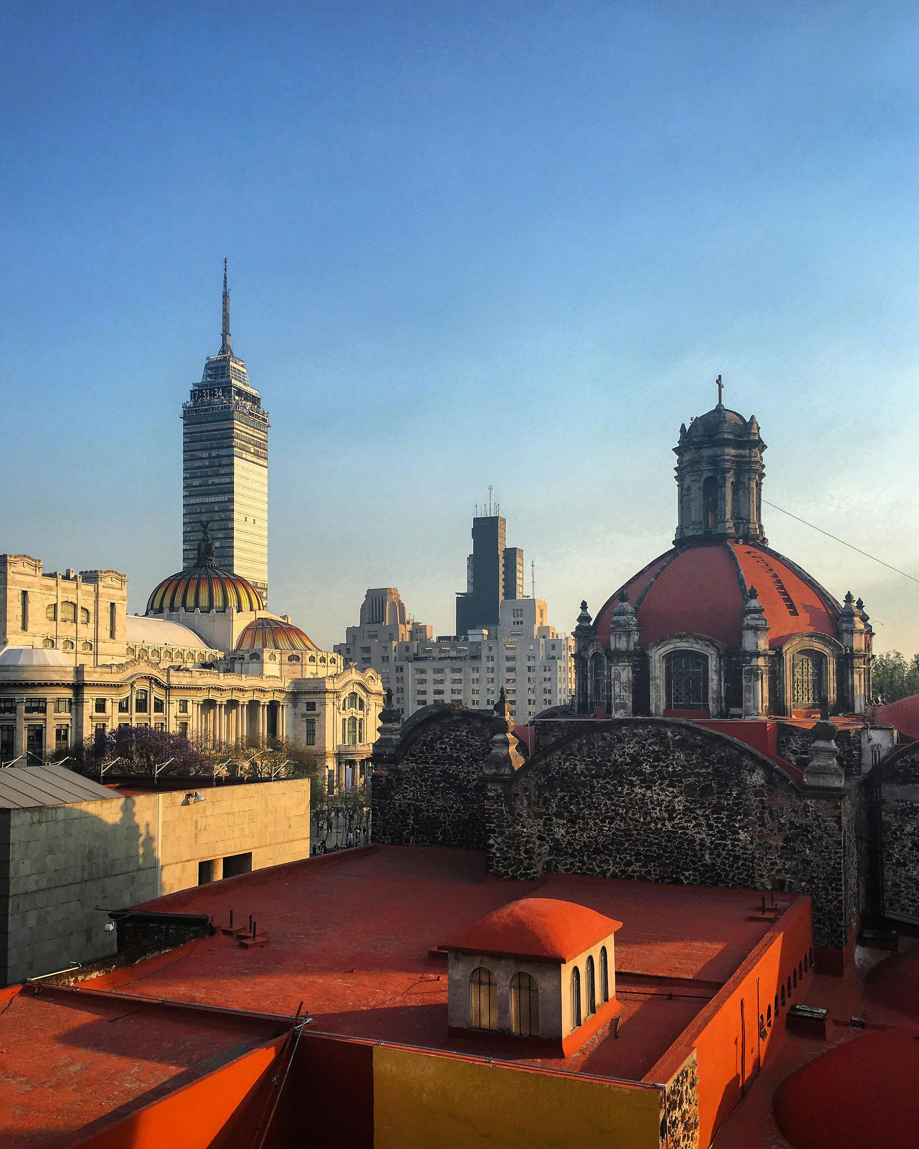 Mexico City skyline featuring Torre Latinoamericana and historic architecture under clear skies.