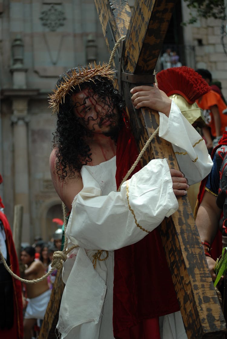 Man On A Easter Procession Carrying Cross As Jesus Christ