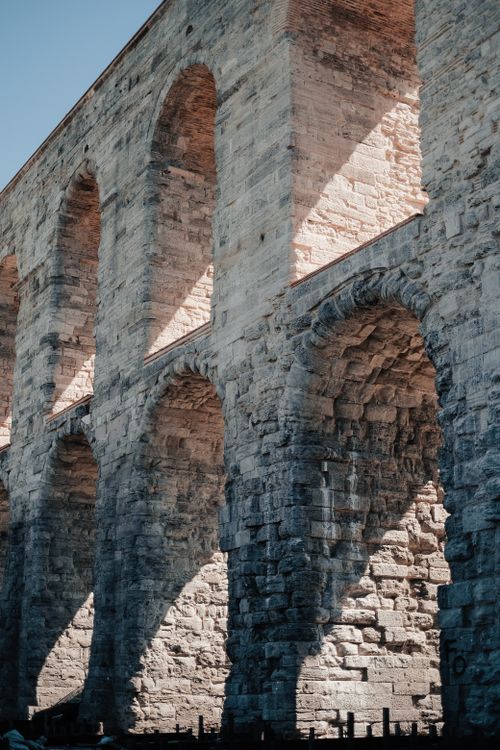 Free Close-up of the historic Aqueduct of Valens in Istanbul with sunlight casting shadows on stone arches. Stock Photo