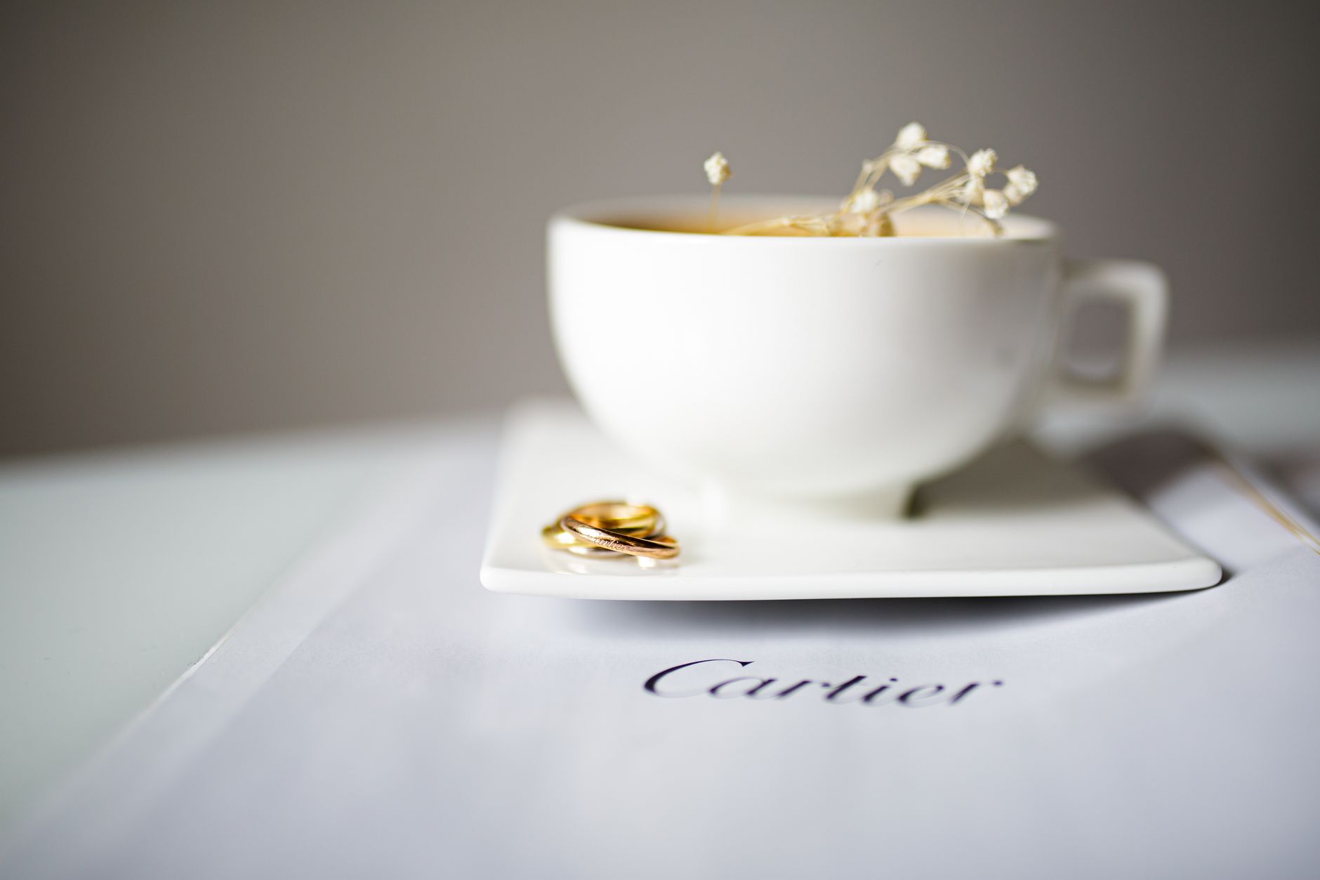 Elegant composition of luxury jewelry with a ceramic cup on a white surface, capturing sophistication.
