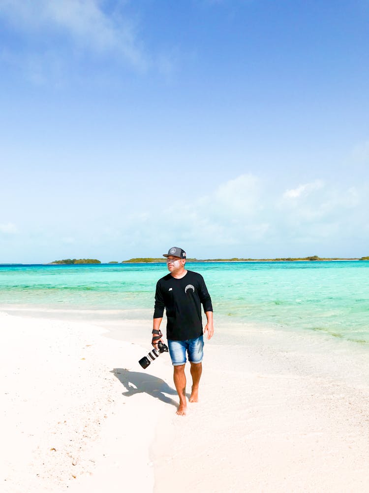 A Photographer Walking On The Shore