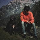 一名男子在印度西姆拉带着狗欣赏雪山风景