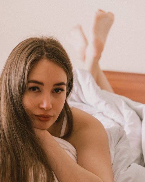 Close Up Photo of Beautiful Woman Lying on Bed