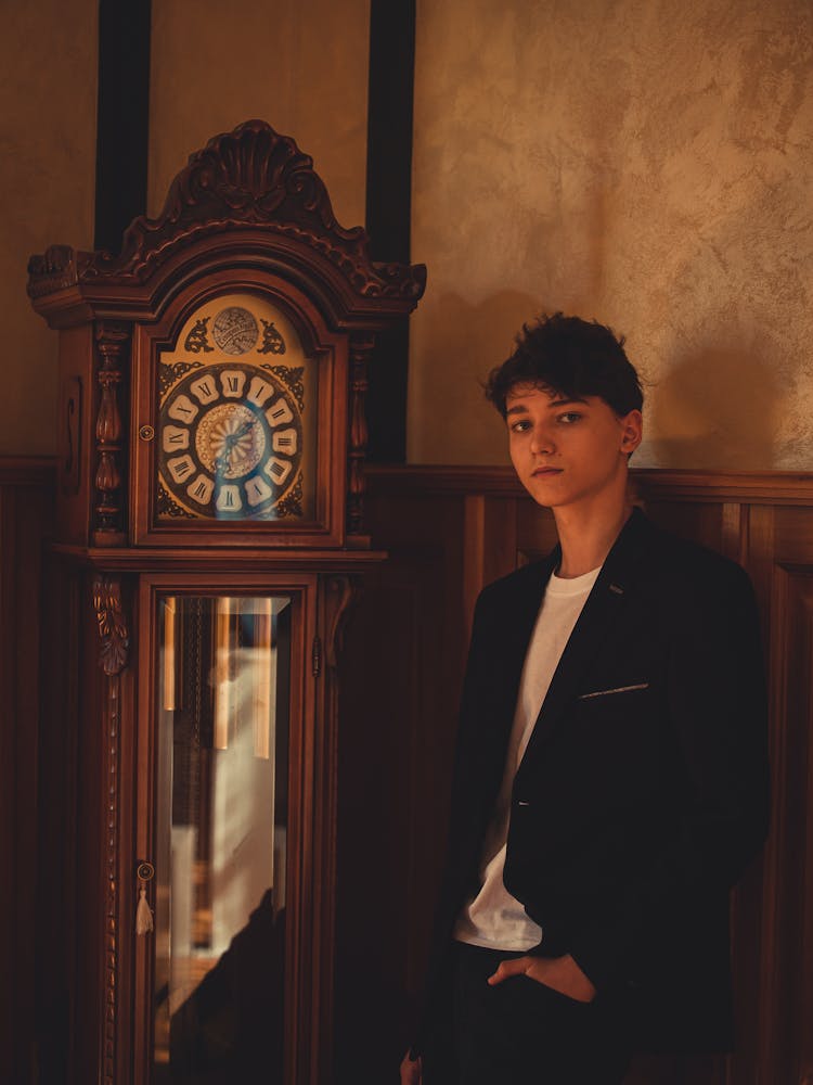 A Man Standing By A Clock