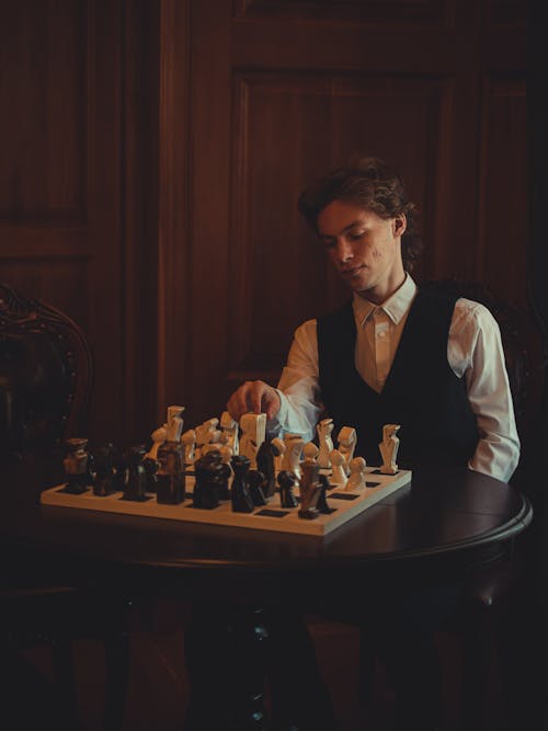 Man in White Dress Shirt with Vest  Playing Chess
