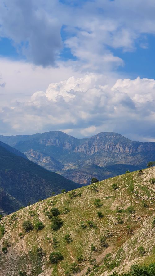 Free Breathtaking view of a mountain range under a vibrant blue sky with clouds. Stock Photo