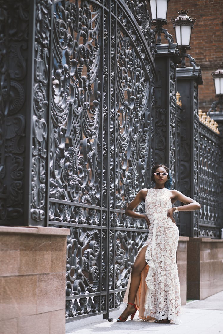 Woman Standing Beside Black Steel Gate