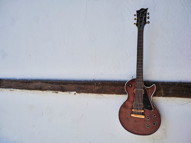 Old Guitar Hanging On Wall