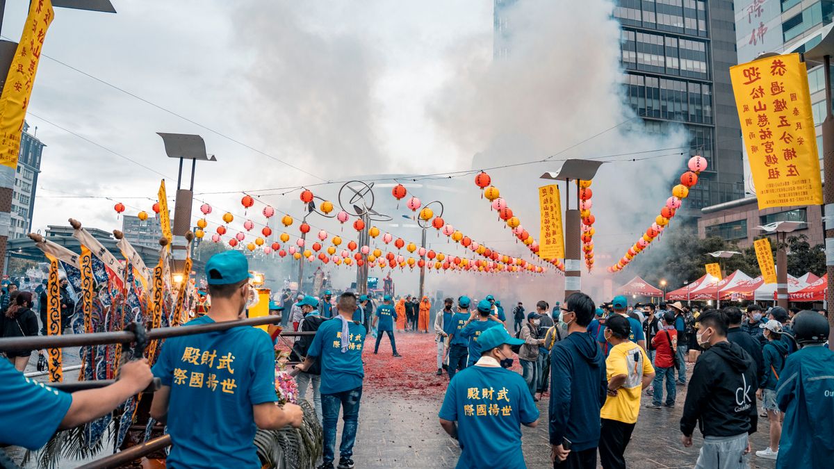 타이베이 등불축제 — Colorful urban festival scene with people, lanterns, and firecrackers creating vibrant atmosphere.