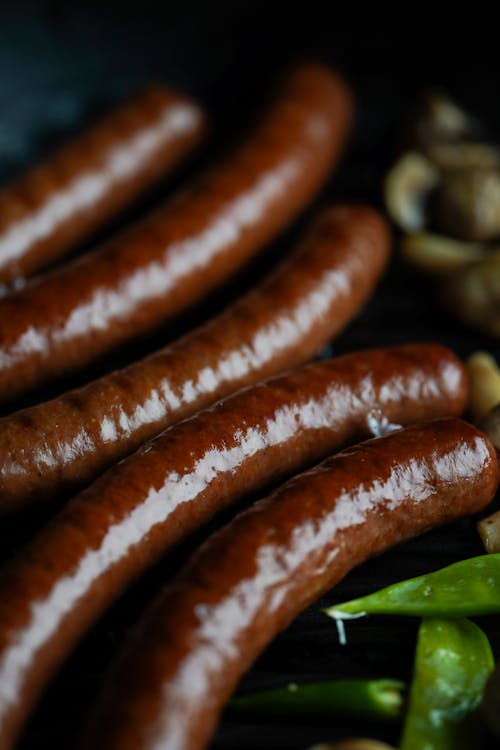 Free Brown Sausage on Green Vegetable Stock Photo