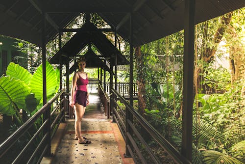 Woman Standing on Hallway in Between Grass