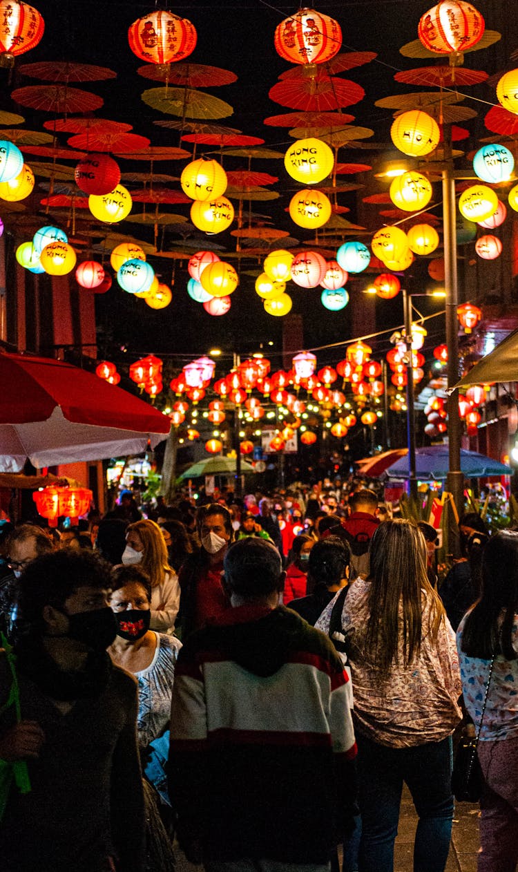 People Walking Under Colorful Lanterns